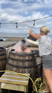 Rob getting water thrown on his head, in a plunge barrel
